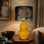 Load image into Gallery viewer, Rounded Gold ceramic table lamp in a lounge setting