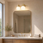 Load image into Gallery viewer, Two-light gold wall sconce above a bathroom vanity