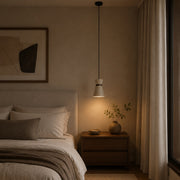 Single travertine pendant light beside a calm bedroom