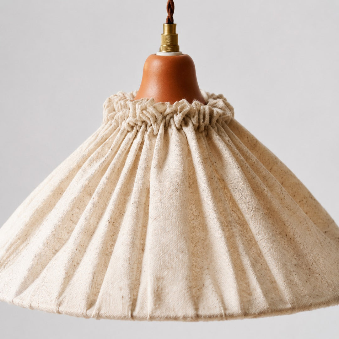 Close-up of gathered pleats around the natural linen pendant shade
