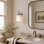 Cargar imagen en el visor de la Galería, Chrome ribbed glass wall sconce installed beside a bathroom mirror