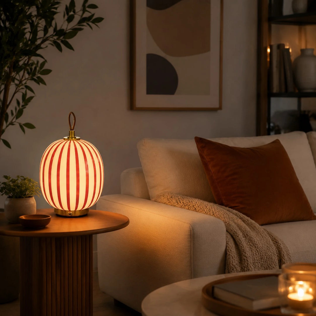 Red striped glass table lamp glowing in an evening interior