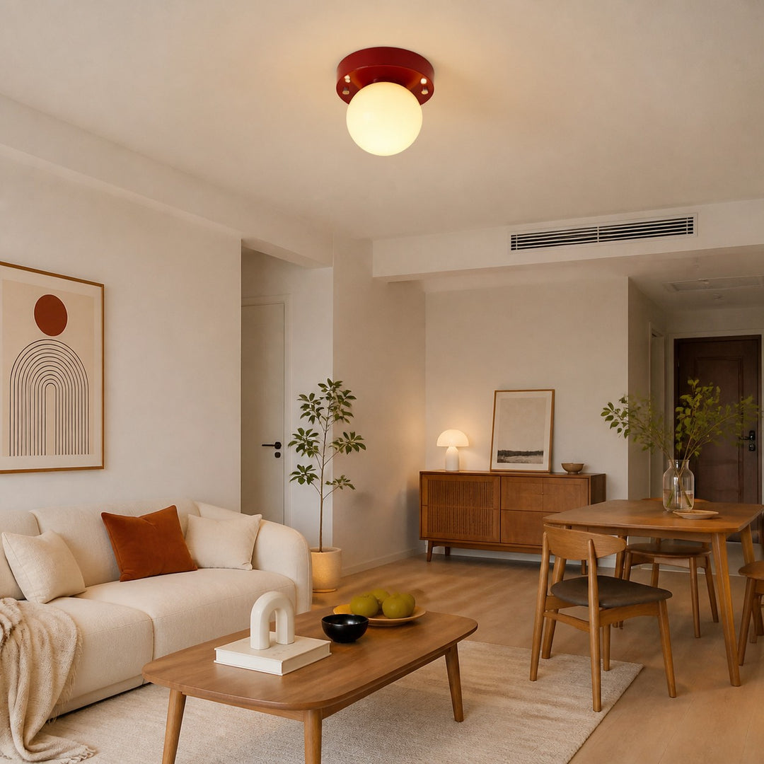 Red glass LED ceiling light illuminating an open living and dining room