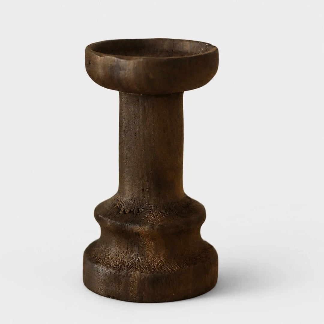 Tall dark solid wood candle holder on a neutral background
