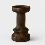 Tall dark solid wood candle holder on a neutral background
