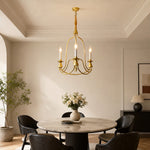 Load image into Gallery viewer, Gold three-light candle chandelier in a bright dining nook