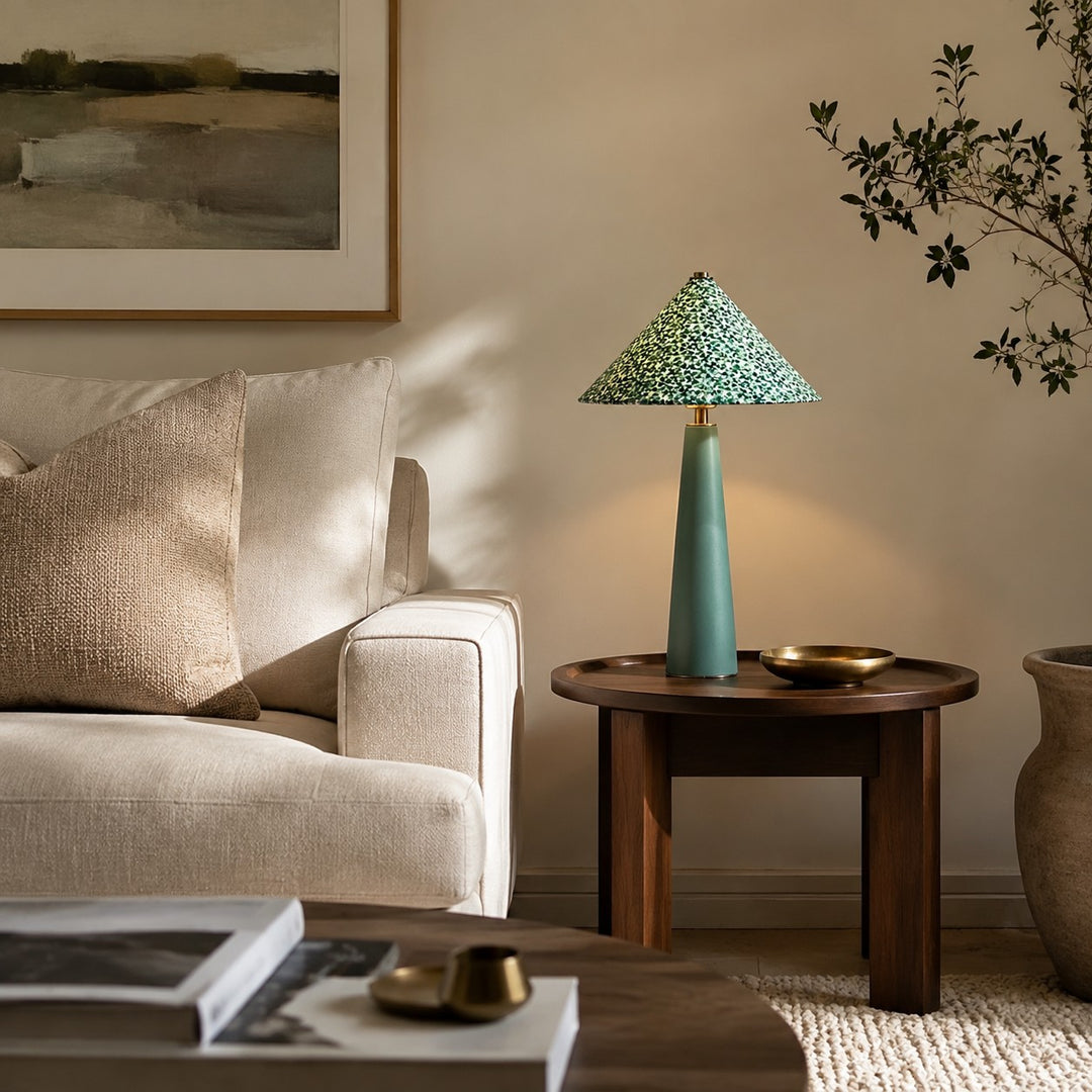 Green floral table lamp beside a sofa