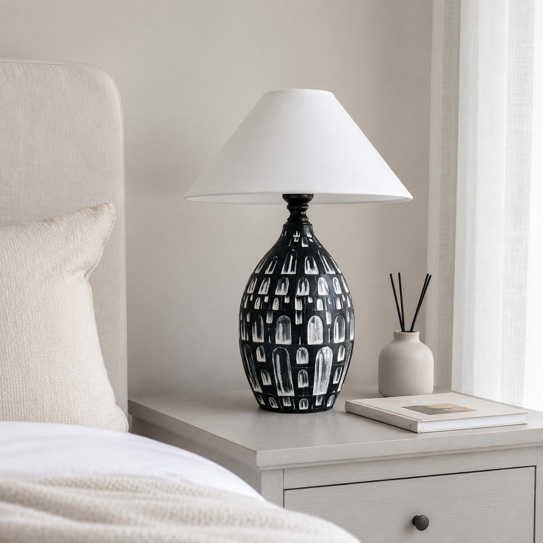 Black ceramic table lamp on a bedside table