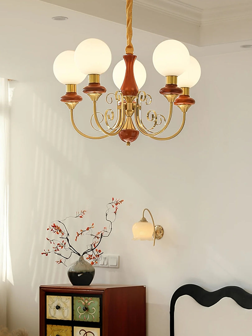 Elegante lámpara de araña con brazos curvos e iluminación ambiental.