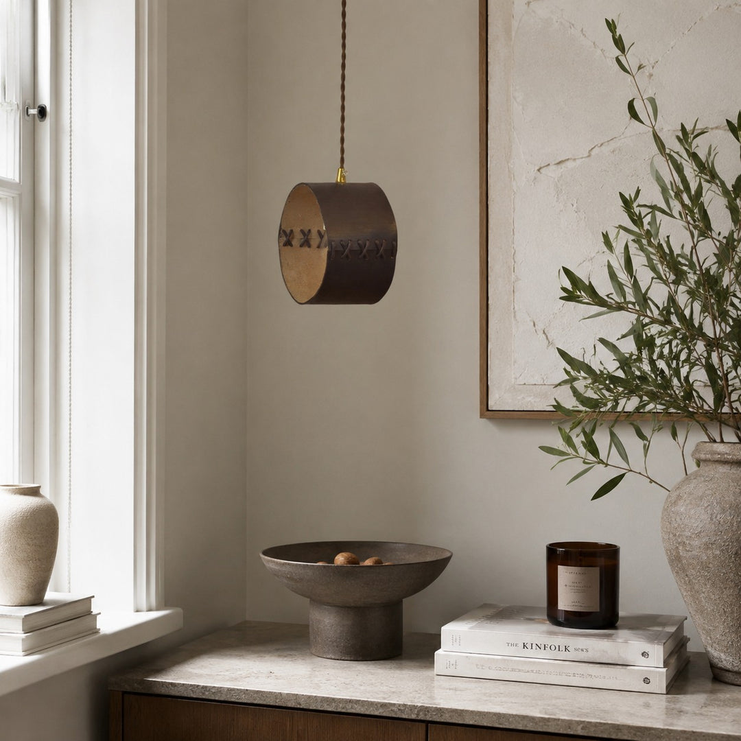 Hand-laced leather cylinder pendant light in an interior setting