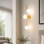 Load image into Gallery viewer, Three-light glass wall sconce in a styled interior