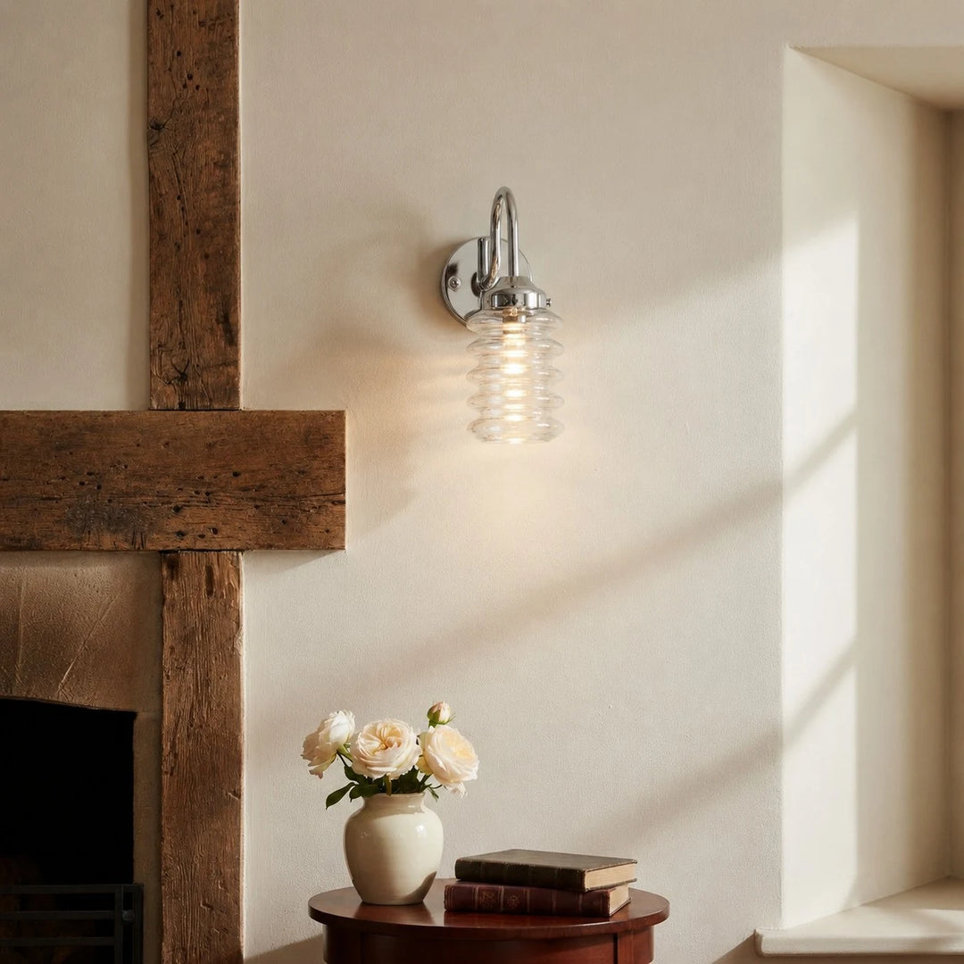 Chrome ribbed glass wall sconce adding soft light to a plaster wall
