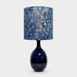 Load image into Gallery viewer, Blue gold patterned fabric ceramic table lamp on plain background
