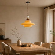 Caramel yellow glass pendant light above a dining table