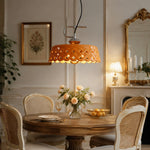 Load image into Gallery viewer, Orange metal and ceramic pendant light installed above a round dining table