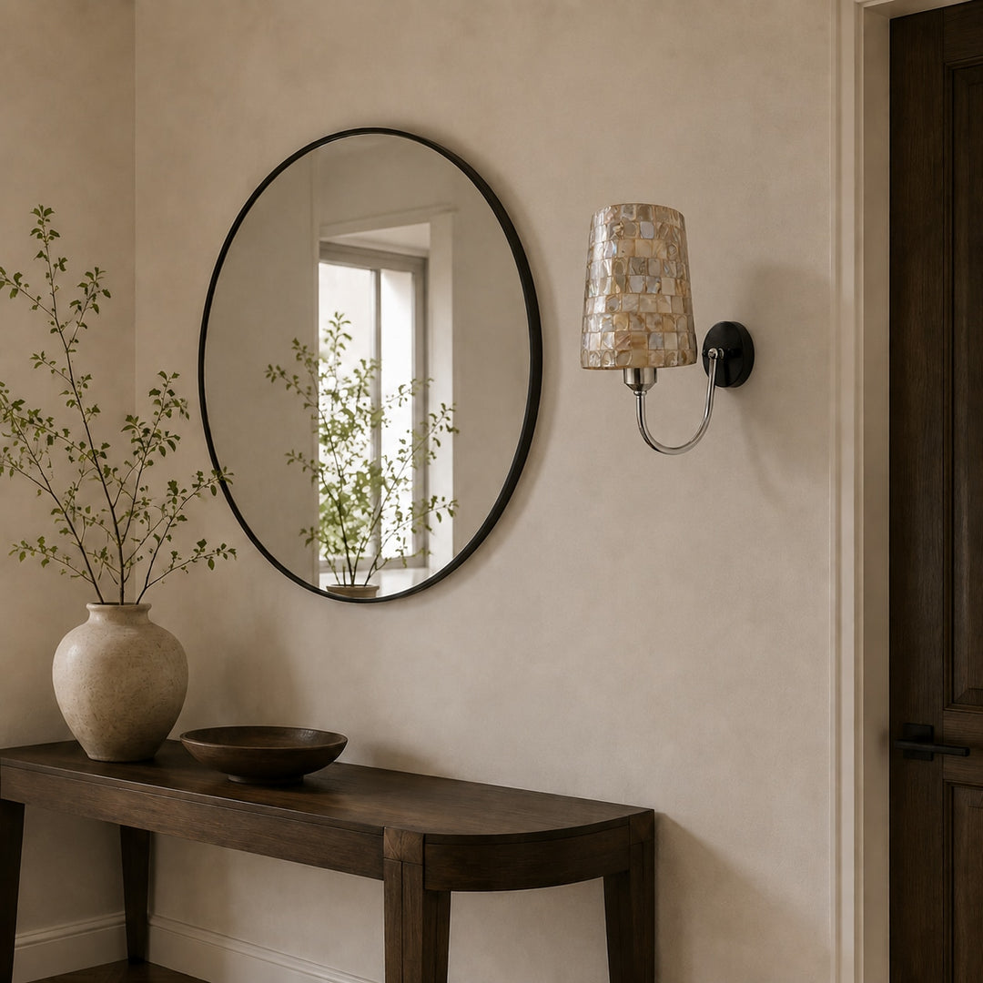 Capiz shell wall sconce beside an entry mirror and console table