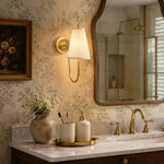 Bild in Gallery-Viewer laden, Brass fabric wall sconce installed near a vanity mirror