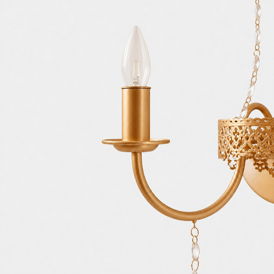 Close view of the curved candle arm and antique brass finish