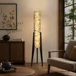 Load image into Gallery viewer, Vintage ivory floral floor lamp glowing beside a lounge chair and wood cabinet