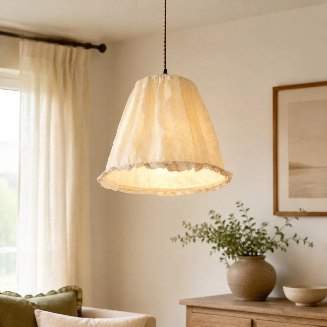 Ivory fabric pendant light glowing in a soft neutral interior