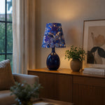 Load image into Gallery viewer, Blue floral ceramic table lamp styled near a window