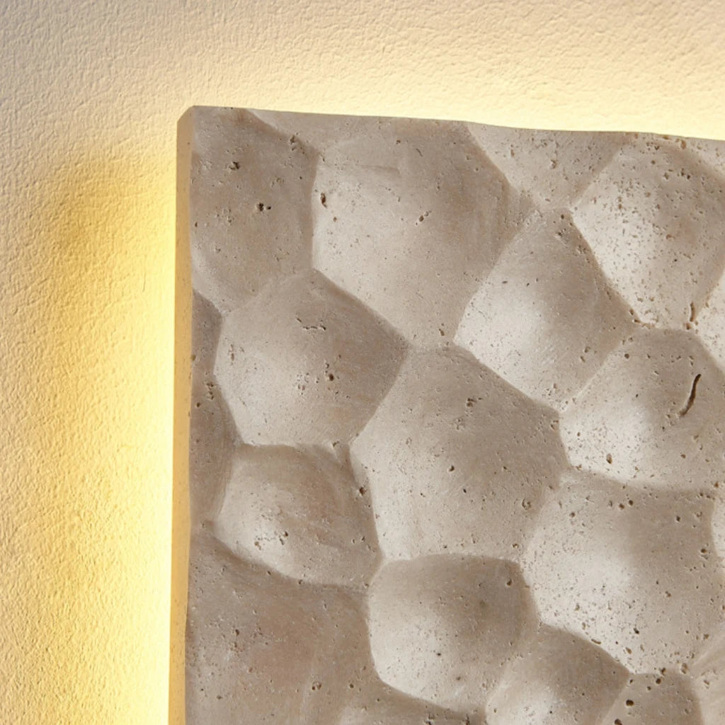 Side depth and hand-finished stone profile of the travertine wall sconce