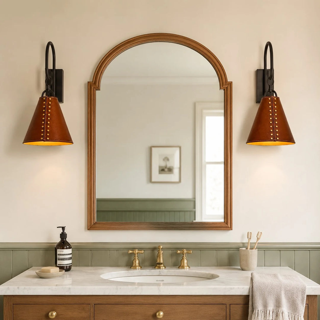 Pair of black and red leather wall sconces installed beside a bathroom mirror