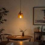 Load image into Gallery viewer, Amber glass pendant light above a dining table