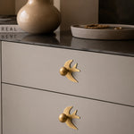 Cargar imagen en el visor de la Galería, Antique brass swallow handles on a neutral dresser