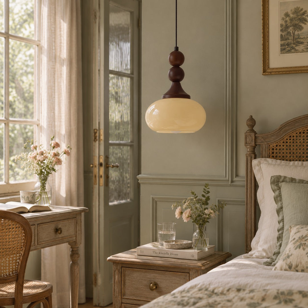 Cream glass pendant beside a bedroom bed