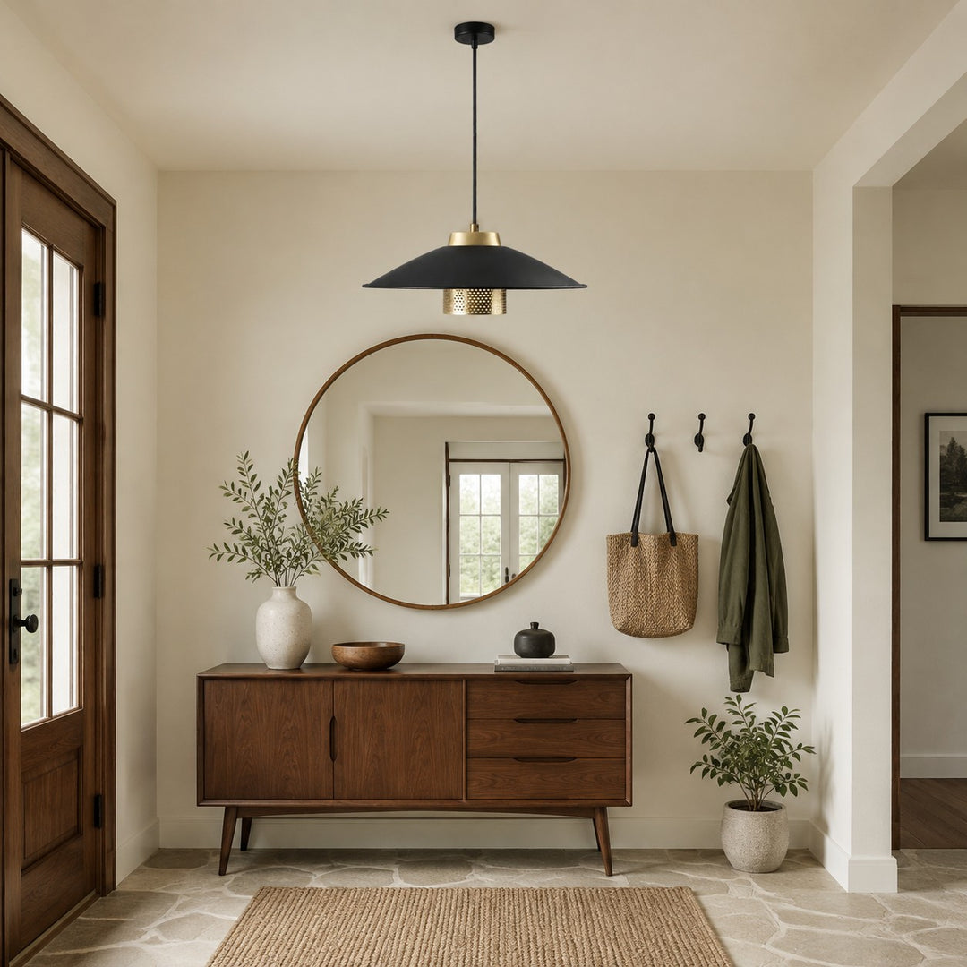 Black and brass pendant light above a wood console in a neutral entryway