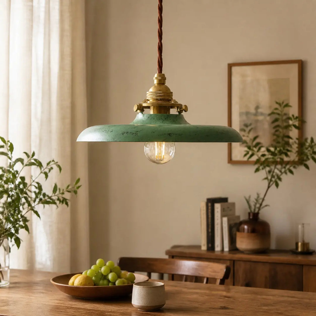 Distressed green pendant light above a dining table
