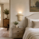 Charger l'image dans la visionneuse de galerie, Travertine wall sconce used beside a bed as a warm bedside wall light