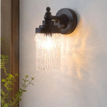 Bild in Gallery-Viewer laden, Averra matte black wall sconce casting warm light near an entryway
