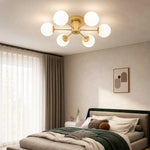 Load image into Gallery viewer, Gold globe ceiling light in a calm modern bedroom