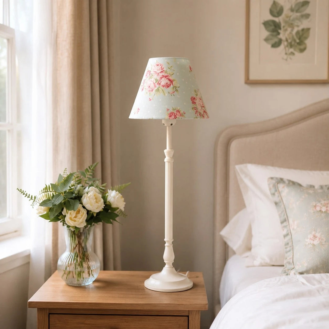 Blue floral French country table lamp beside a bed