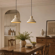 Beige metal pendant lamp above a dining table scene
