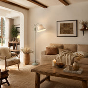 Sage green floor lamp beside a sofa in a warm country living room