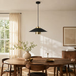 Bild in Gallery-Viewer laden, Black and brass pendant light centered above a round walnut dining table