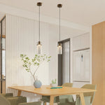 Cargar imagen en el visor de la Galería, Pair of brass glass pendant lights installed above a kitchen dining table
