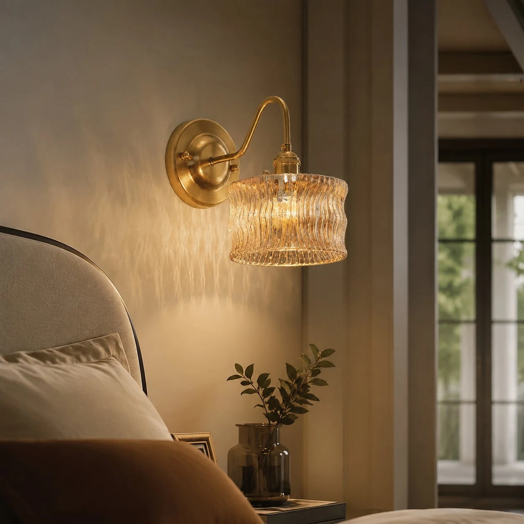 Amber ripple glass wall light casting warm bedside texture