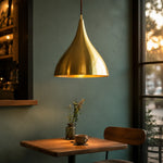Load image into Gallery viewer, Solid brass pendant light above a warm dining table