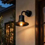 Charger l'image dans la visionneuse de galerie, Black wall sconce lighting an exterior wall beside a window