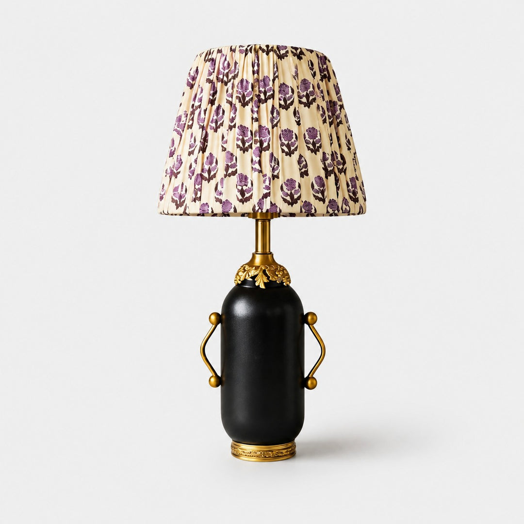 Matte black vintage table lamp with purple floral pleated shade on white background