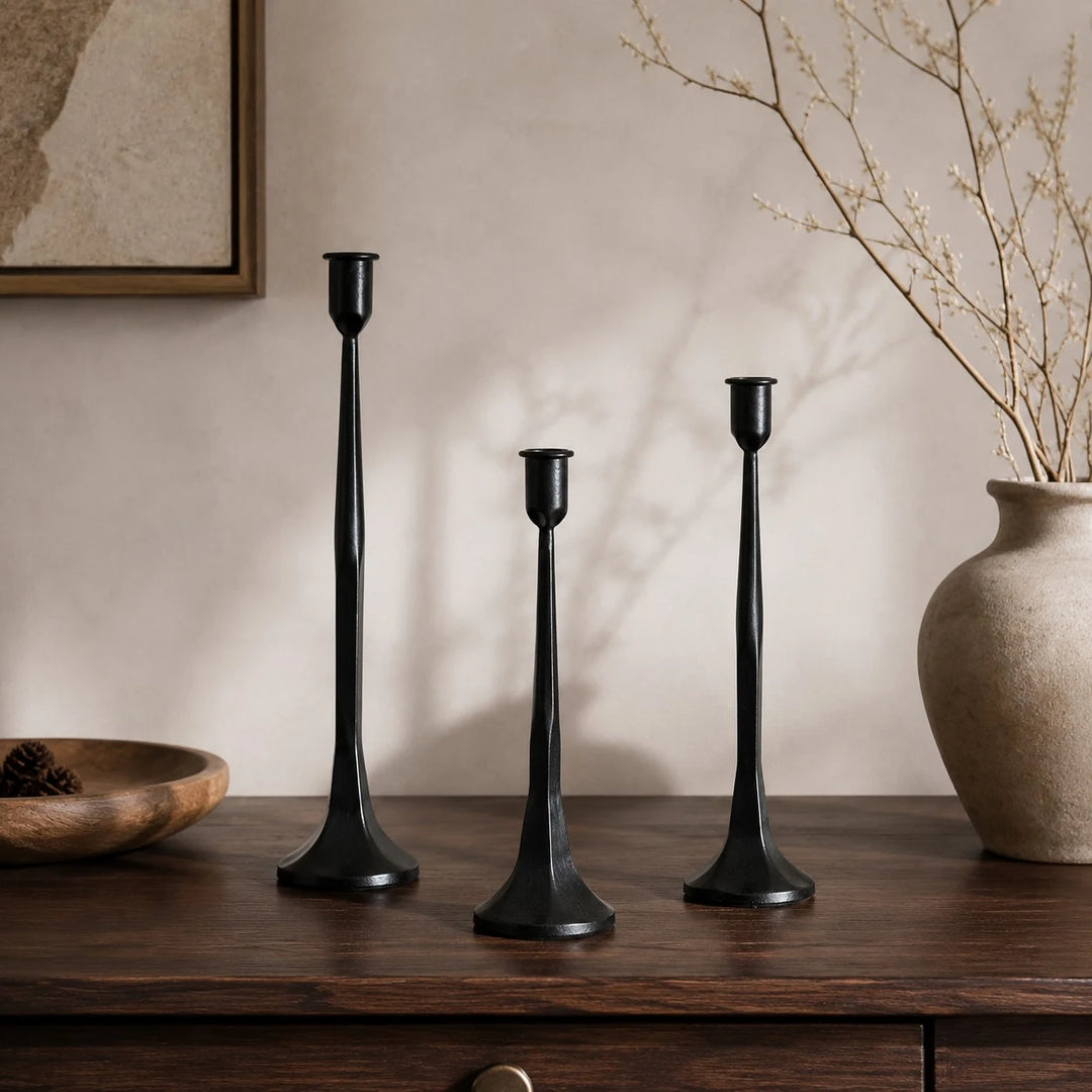 Black iron candle holder set styled on a warm wabi-sabi console table