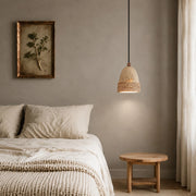 Wabi-sabi woven stone pendant light installed beside a bed