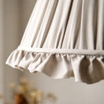 Load image into Gallery viewer, Close view of the pleated fabric shade and scalloped trim