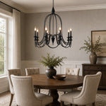 Load image into Gallery viewer, Black eight-light candle chandelier over an oval dining table