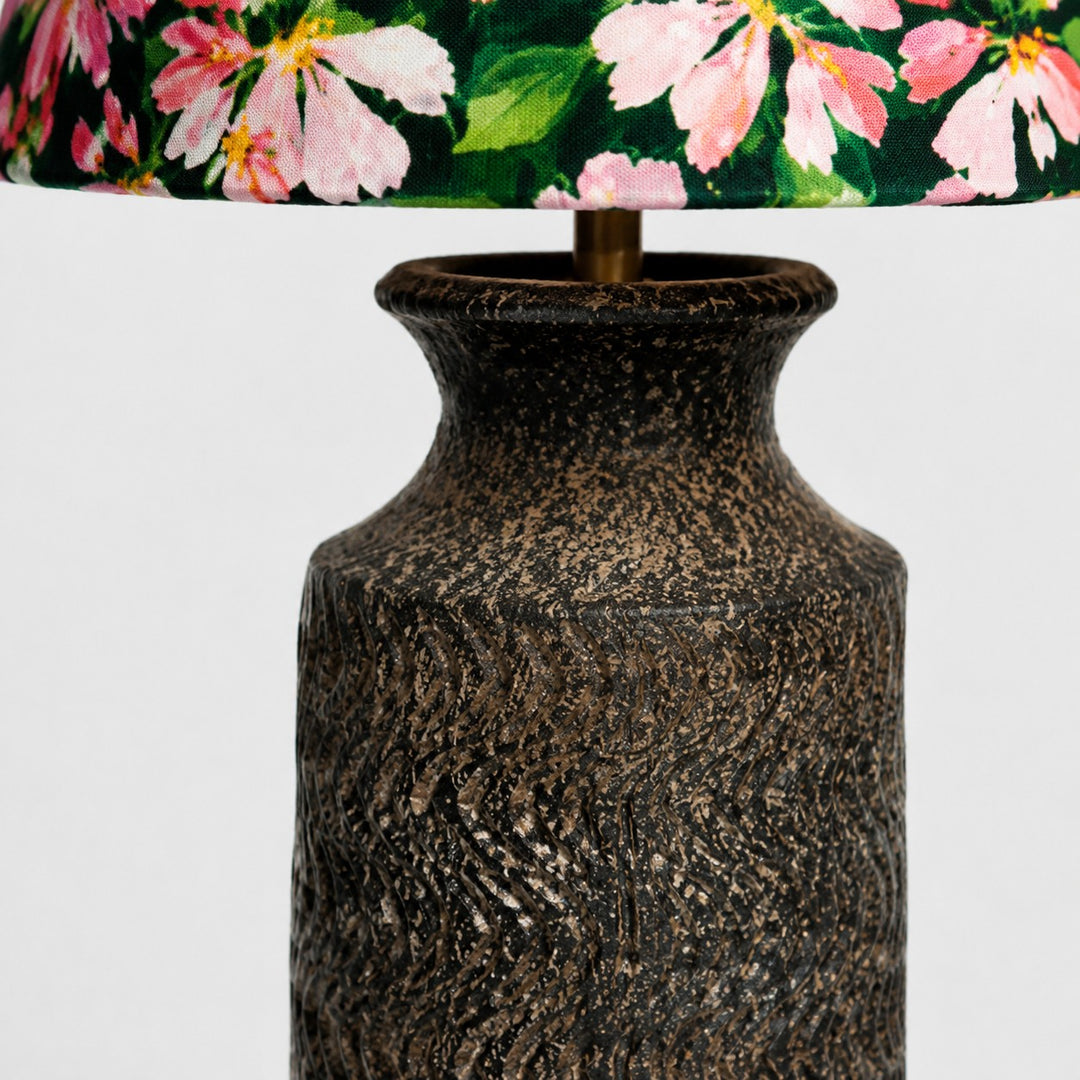 Close-up of brass stem connection between floral shade and ceramic base
