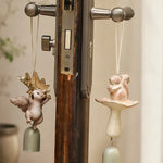 Cargar imagen en el visor de la Galería, Two warm ivory squirrel wind chime styles hanging on a handle